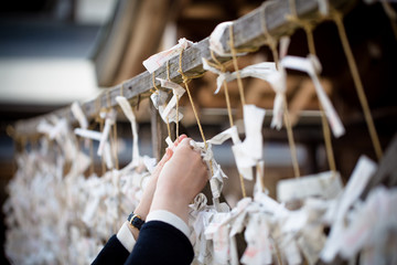 'Omikuji' at Yasaka Shrine, Japan. Omikuji is fortune telling paper strip. People leave the omikuji behind if it's not a good one.