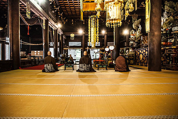 寺院の中で早朝に祈る仏教の僧侶 - お寺 ストックフォトと画像